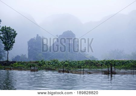 Tam Coc - Bich Dong tourist destination in minst in the monsoon near Ninh Binh, Vietnam