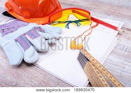 Orange hard hat, earplug, safety glasses and gloves for work. Earplug to reduce noise on a white background