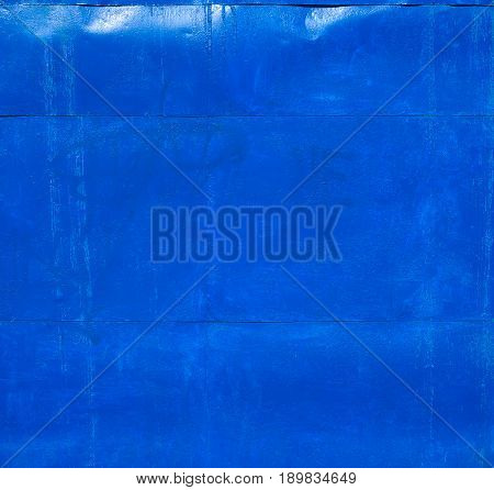 Blue rusty metal texture. Wall of sheet metal painted in blue