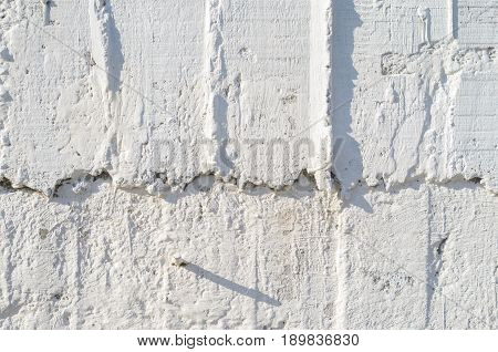 Texture of wooden formwork stamped on a raw concrete wall as background. Vertical strips from formwork