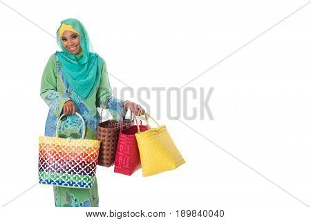 Beautiful asian muslimah woman with bright wicker tote bags. Isolated on the white studio background.Copyspace
