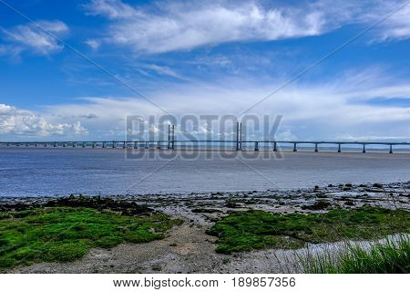 Severn suspension bridge toll crossing between England and Wales on a bright blue sky day.