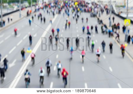 Abstract blurred background of mass cycling marathon in the streets of the city. Participants and athletes go back to us. Concept of Sport, healthy lifestyle, aktivity. Selective focus. For backdrop