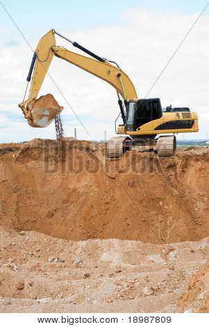 Gelbe Bagger Radlader auf Baustelle mit erhöhten Eimer voller sand