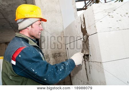 pedreiro de trabalhador de pedreiro de construção fazendo uma alvenaria com colher de pedreiro