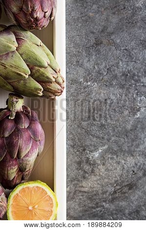 Baby Ripping Organic Artichokes With Lemon. Food For A Vegan And