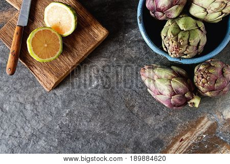 Baby Ripping Organic Artichokes With Lemon. Food For A Vegan And