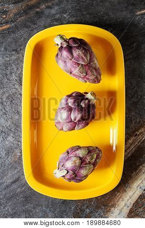 Baby Ripping Organic Artichokes With Lemon. Food For A Vegan And