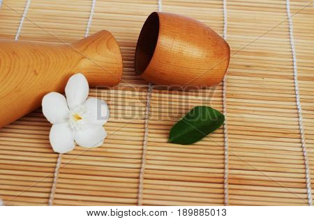 SAKE liqueur in a brown wooden bottle on a light brown background.