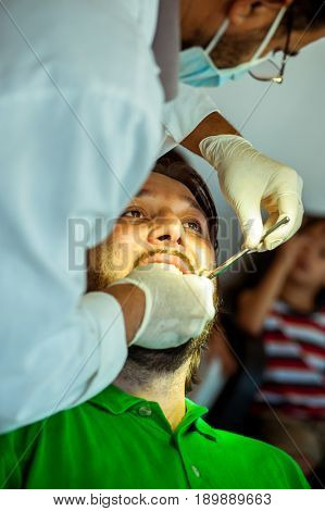 Man at the dentist clinic fixing his teeth