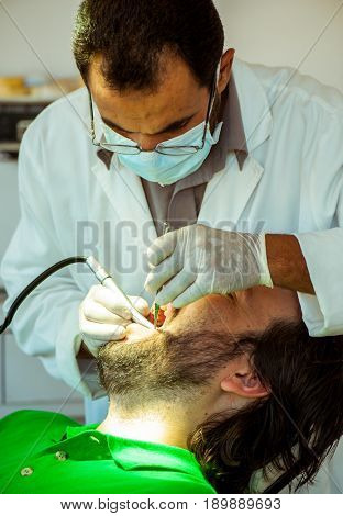 Man at the dentist clinic fixing his teeth