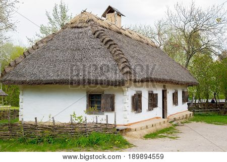 Ancient peasant Ukrainian house in the spring with a thatched roof in the old village of national architecture Ukraine. National Museum Pirogovo in the outdoors near Kiev.