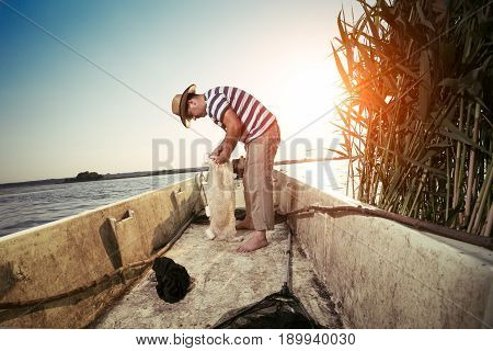 Old fisherman untangling the net  closeup picture