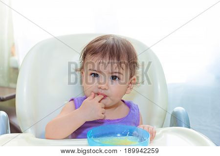 baby eating in the kitchen on the sittting on the table