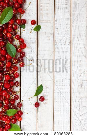 Ripe cherries on wooden table. View from above with copy space