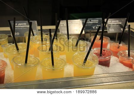 Fresh fruit smoothies at a self service counter at a restaurant (text on tags: price and product information in Dutch)