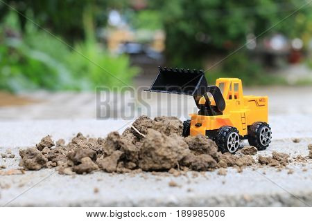 Truck Toy Car With Sand And Soil On The Concrete Floor With Blur Boken Green Environment  Constructi