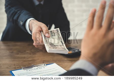 Businessman refusing money Japanese yen bills - anti bribery and corruption concepts