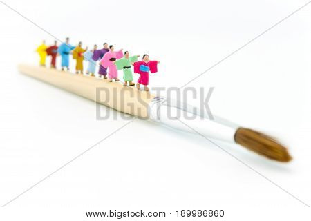 miniature Japannese peoples wearing kimono walking on paintbrush