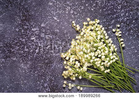 bunch of lily of the valley on a textured cement background with copy space