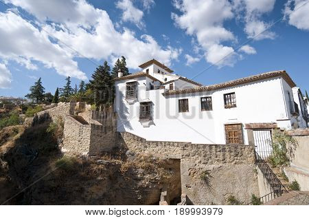 Cliffs under Ronda town, Malaga, Andalusia, Spain. The Guadalevin River runs through the city dividing it in two and carving out the steep 100 plus meters deep El Tajo canyon upon which the city perches
