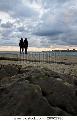 Due persone guardando la città sotto il cielo al tramonto.