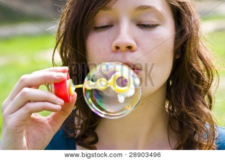 Czerwone włosy kobieta gra z baniek mydlanych