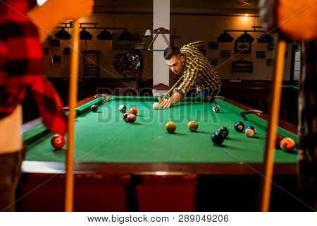 Friends plays american billiard in poolroom