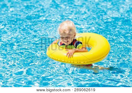 Child In Swimming Pool On Toy Ring. Kids Swim.