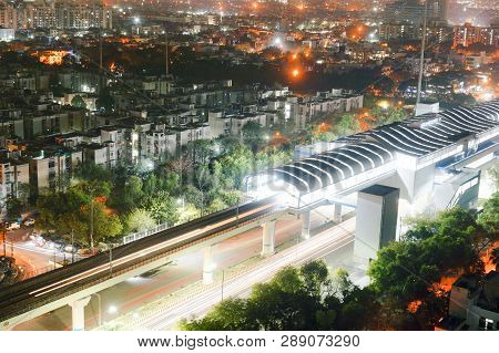 Aerial Shot Of Lit Metro Sation With Trails From Leaving Train And Traffic