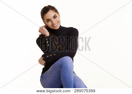 Cheerful Young Woman Sitting At Isolated White Background