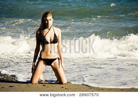 Sexet ung pige poserer på stranden