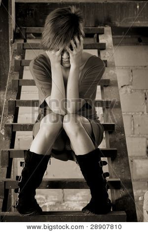 Bella donna bionda che copre il viso con le mani.
