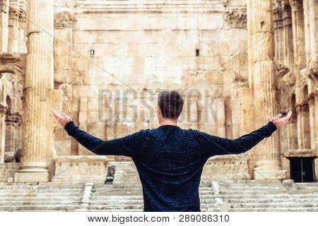 Man Looking On Historic Ancient Roman Bacchus Temple In Baalbek, Lebanon