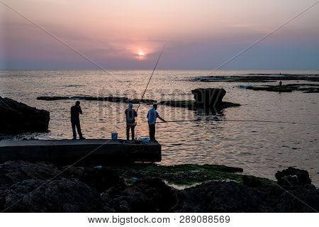 Byblos - Lebanon - A Man Fishing In Front Of The Sun In Byblos Harbour Lebanon 2018