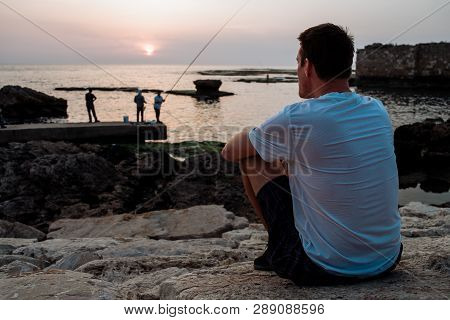 Byblos - Lebanon - A Man Fishing In Front Of The Sun In Byblos Harbour Lebanon 2018