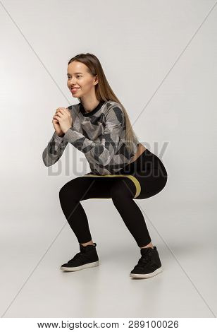 Young Sporty Woman Squatting Doing Sit-ups With Resistance Band
