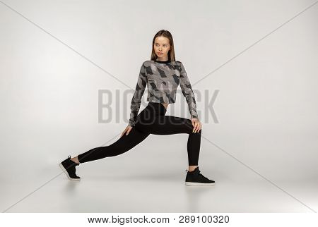 Sporty Yogi Brunette Girl In Dark Sportswear Doing Exercises