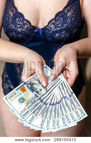 Young Woman Dressed In Blue Lingerie Hold A Money, New One Handred Dollars Banknotes.