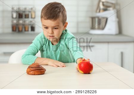 Little Boy With Pastry And Apple At Home. Diabetes Diet