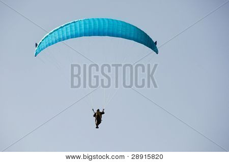 Paraglider สีฟ้าเหนือท้องฟ้า