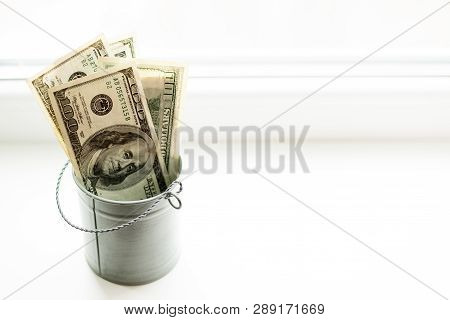 Moneybox, Dollars In Bucket On White Window.light Background. Place For Text. Top View. A Lot Of Mon