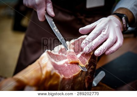 Hands Of A Men Cut A Slice Of Traditionally Spanish Jamon