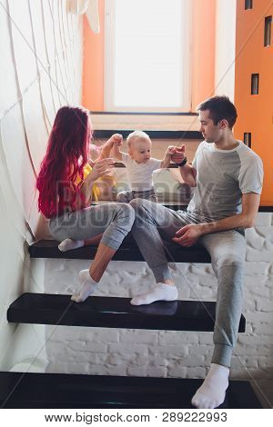 The Father, Mother And Sons Sitting On The Stairs.