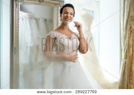 Beautifu bride choosing wedding dress in a wedding salon