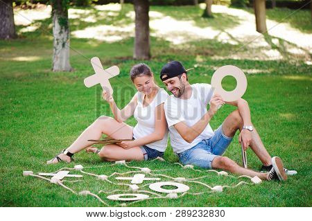 Laughing Boy And Girl Playing Tic-tac-toe In The Park.