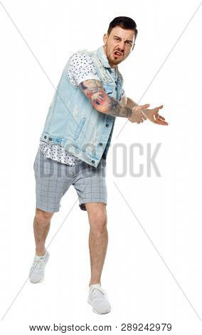 The man screams. Aggressive guy in tattoos yelling at the frame and showing his hands back.  Isolated on white background. A collection of emotional people. angry man shows hands back.