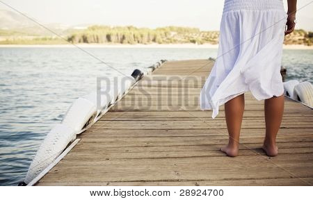 Unge shoeless kvinde på molen.