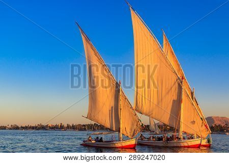 Felucca Boats Sailing On The Nile River In Luxor, Egypt. Traditional Egyptian Sailing Boats