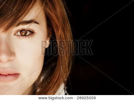 Portrait de femme demi visage, isolée sur fond noir